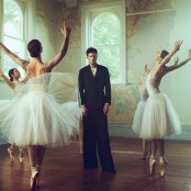 SWIM stood in a black suit surrounded by four ballerinas dancing